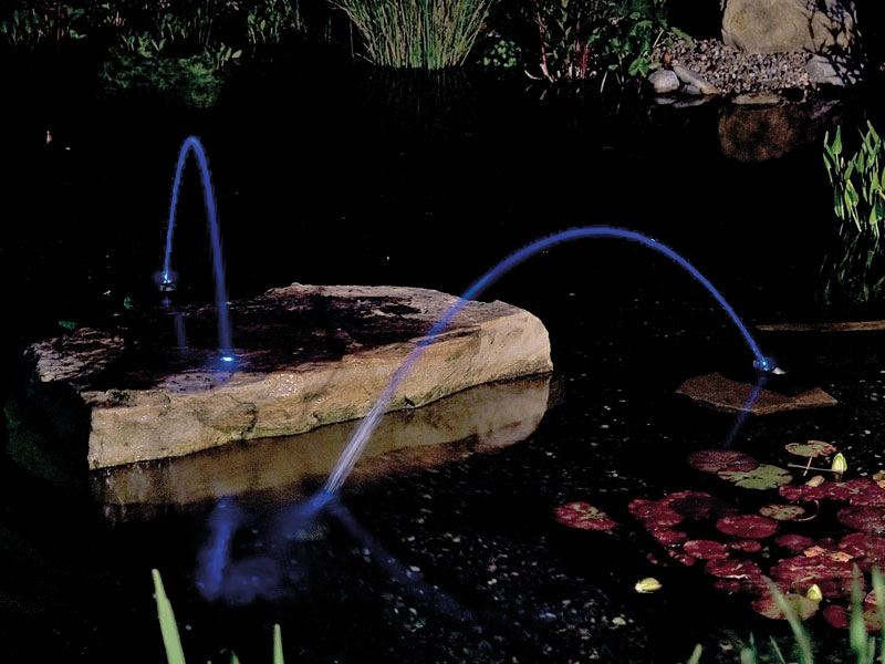 Water Jet Lightning bei Nacht in einem Gartenteich