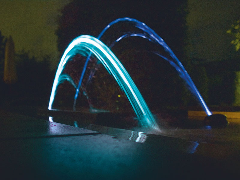 Water Jet Lightning bei Nacht in einem Gartenteich