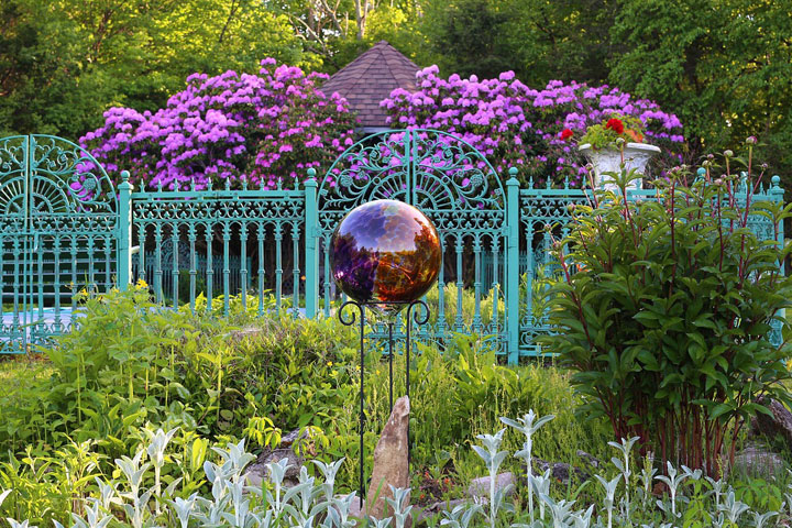 Dekoration und Gestaltung Cottage Garden Glaskugel und Zaun in einem verwachsenen Garten