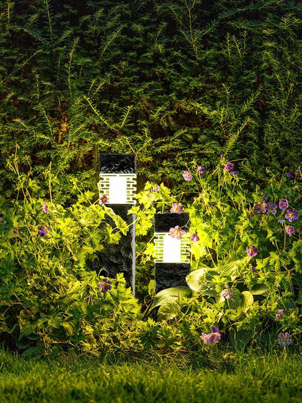 Gartenleuchte Kolossos beleuchtet bei Nacht eine Hecke