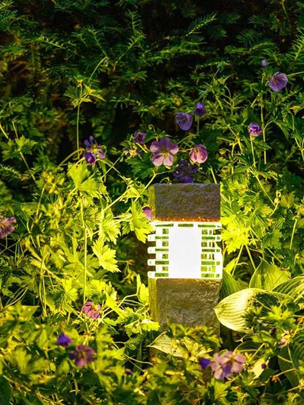 Gartenleuchte Nepos beleuchtet Pflanzen Gartenleuchte Nepos von Pflanzen umgeben in der Dämmerung